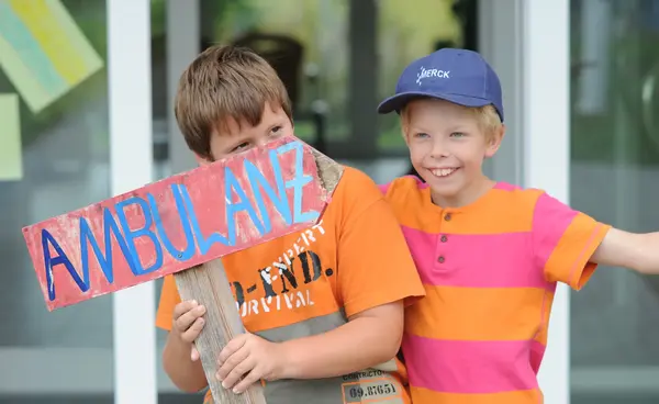 Zwei Jungen mit einem selbstgemalten Ambulanzschild
