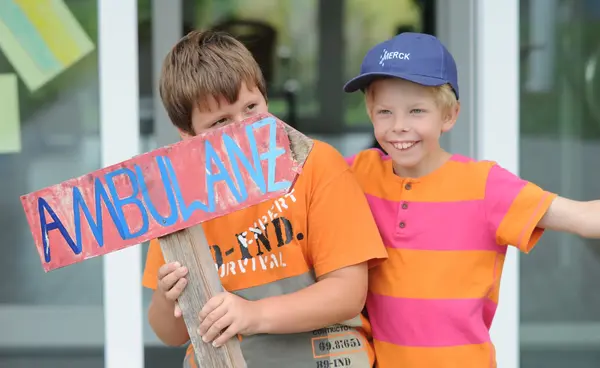 Zwei Jungen mit einem selbstgemalten Ambulanzschild