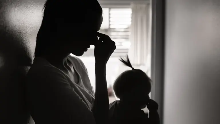 Unglückliche Frau mit Baby auf dem Arm