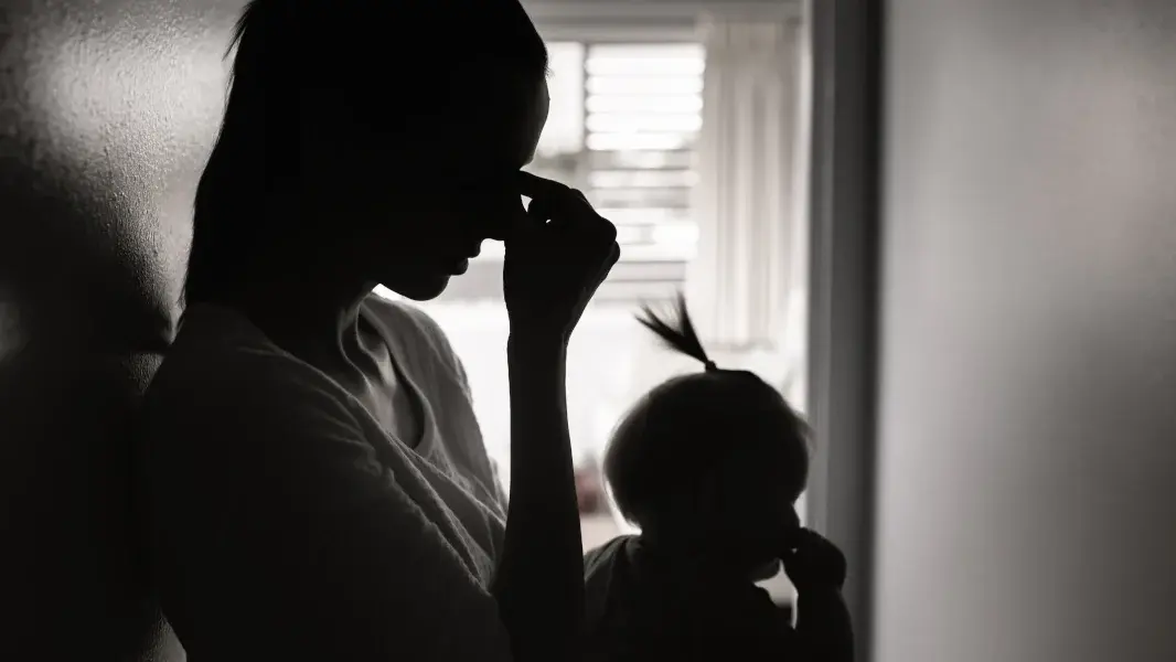 Unglückliche Frau mit Baby auf dem Arm