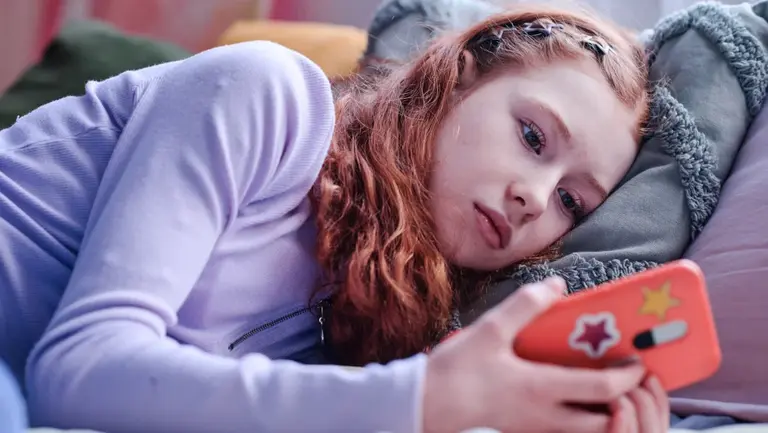 Trauriges Mädchen starrt auf ihr Smartphone