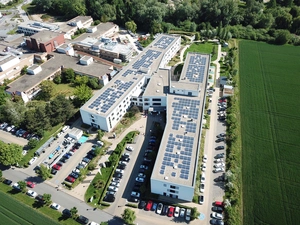 Luftaufnahme des Klinikgebäudes mit Photovoltaikanlage auf dem Dach