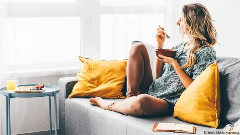 Frau mit Müsli auf dem Sofa