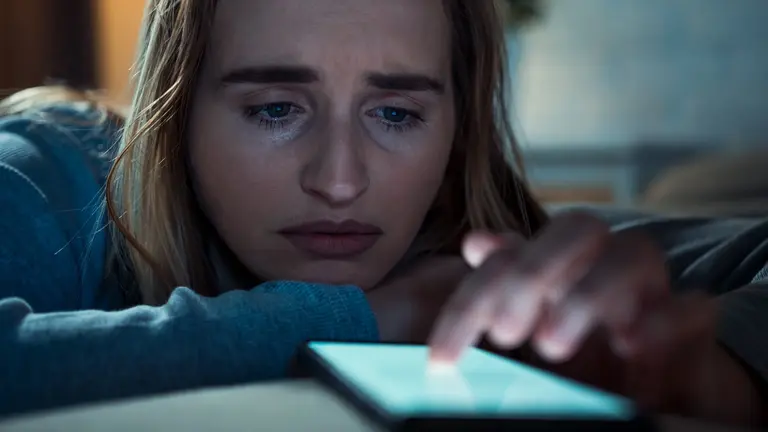 KI als Therapeut Traurige Frau mit Smartphone